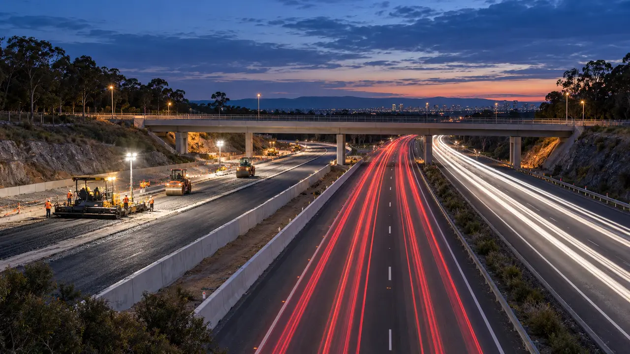 A motorway upgrade at dusk: new lanes being paved beside live traffic